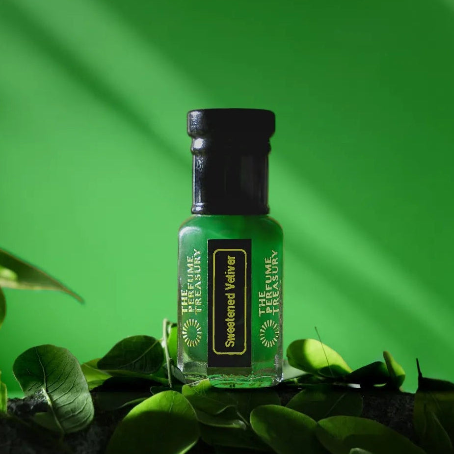 Sweetened Vetiver perfume oil bottle surrounded by fresh green leaves with vibrant botanical luxury aesthetic.