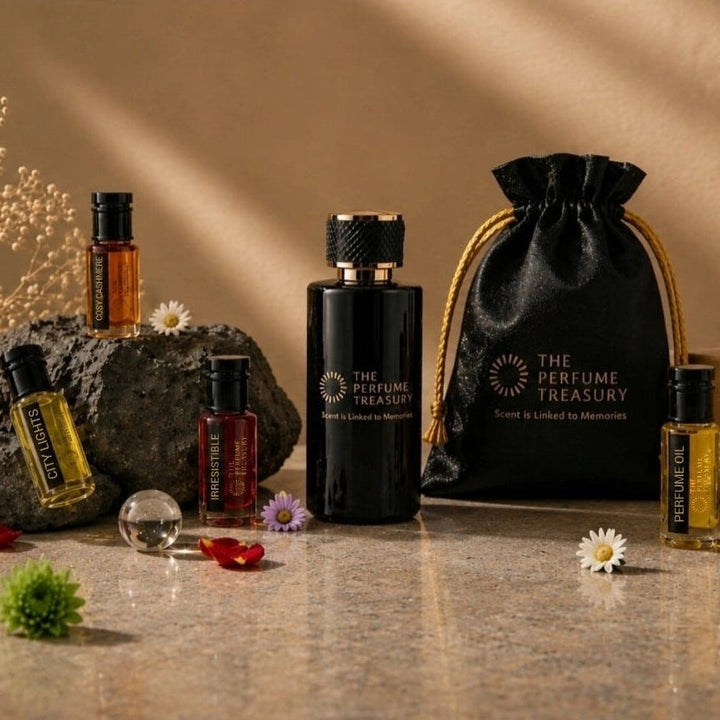 The Perfume Treasury luxury fragrance collection featuring premium perfume oils, essential oils, extrait de parfum and gift pouch displayed in an elegant floral arrangement.