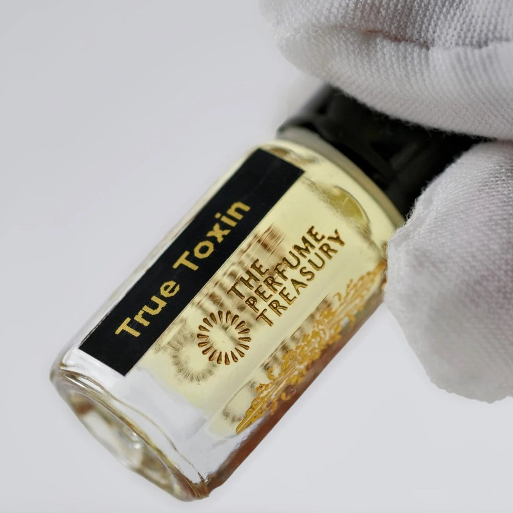 Close-up of True Toxin perfume oil by The Perfume Treasury showing the clear glass bottle and branded label