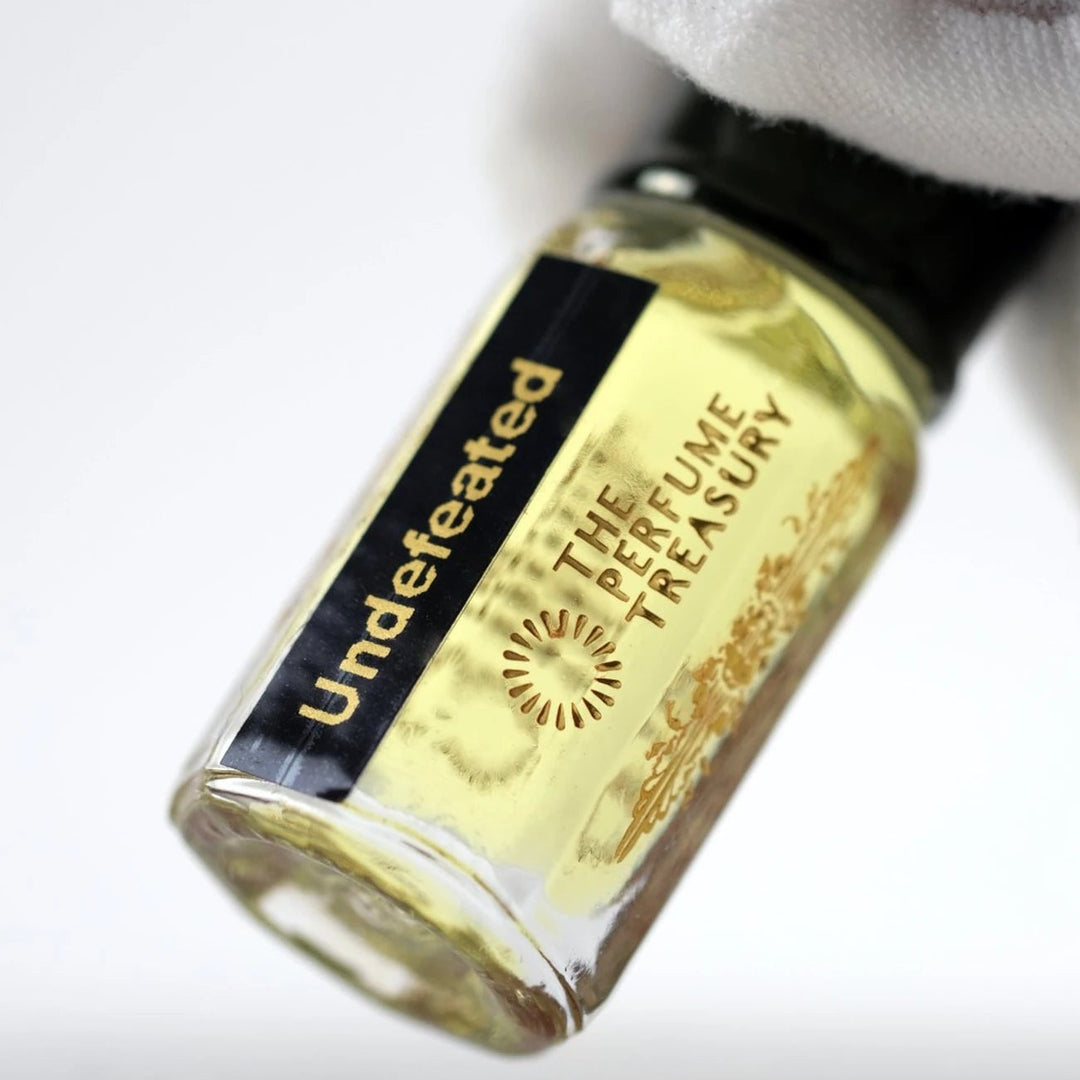 Close-up of Undefeated perfume oil by The Perfume Treasury showing the bottle and black and gold label