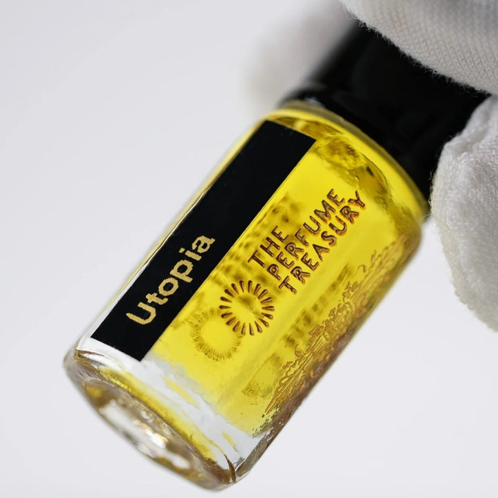 Close-up of Utopia perfume oil by The Perfume Treasury showing the golden oil and black and gold bottle label