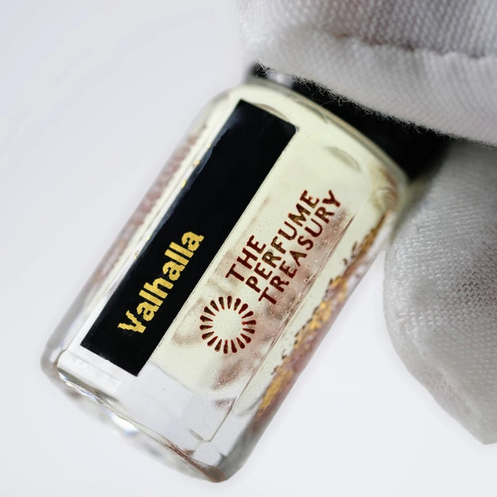 Close-up of Valhalla perfume oil by The Perfume Treasury showing the clear glass bottle and branded label