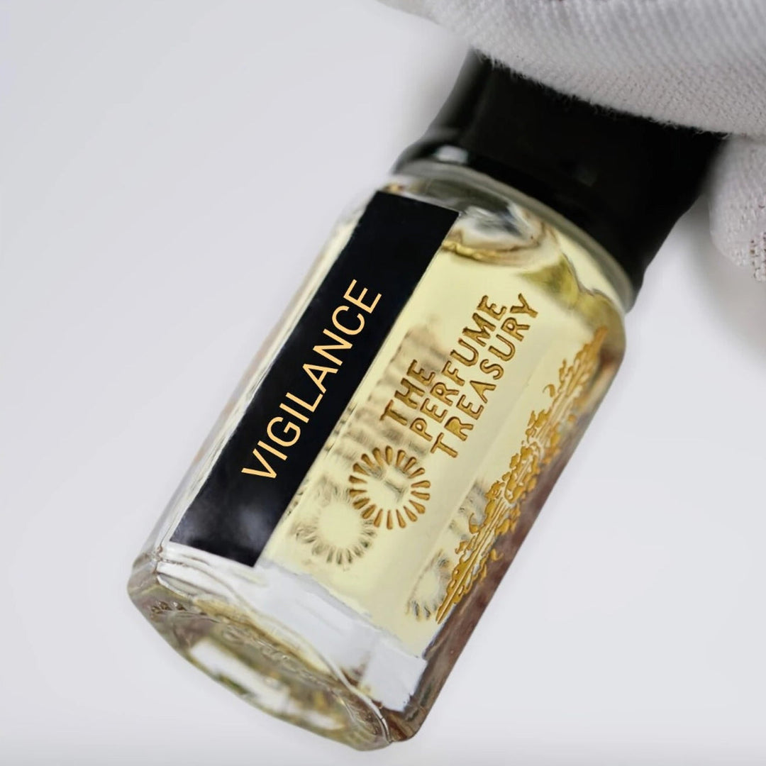 Close-up of Vigilance perfume oil by The Perfume Treasury showing the pale golden oil and branded bottle label