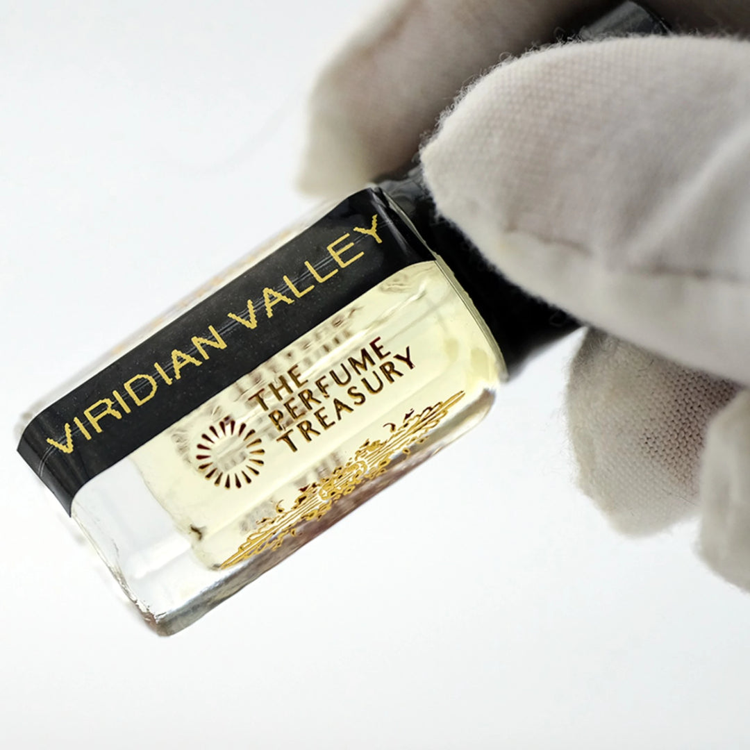 Close-up of Viridian Valley perfume oil by The Perfume Treasury showing the pale golden oil and branded bottle label