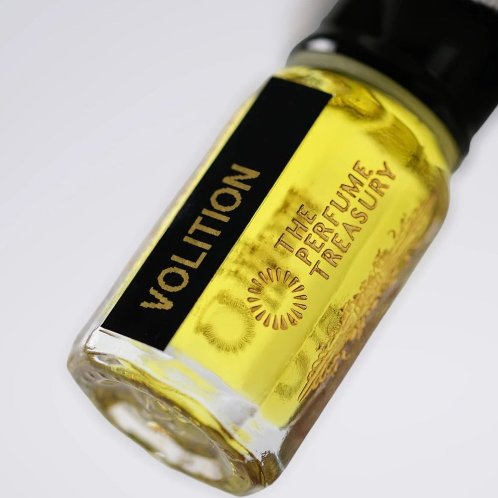 Close-up of Volition perfume oil by The Perfume Treasury showing the vibrant golden oil and branded bottle label