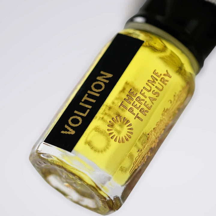Close-up of Volition perfume oil by The Perfume Treasury showing the vibrant golden oil and branded bottle label