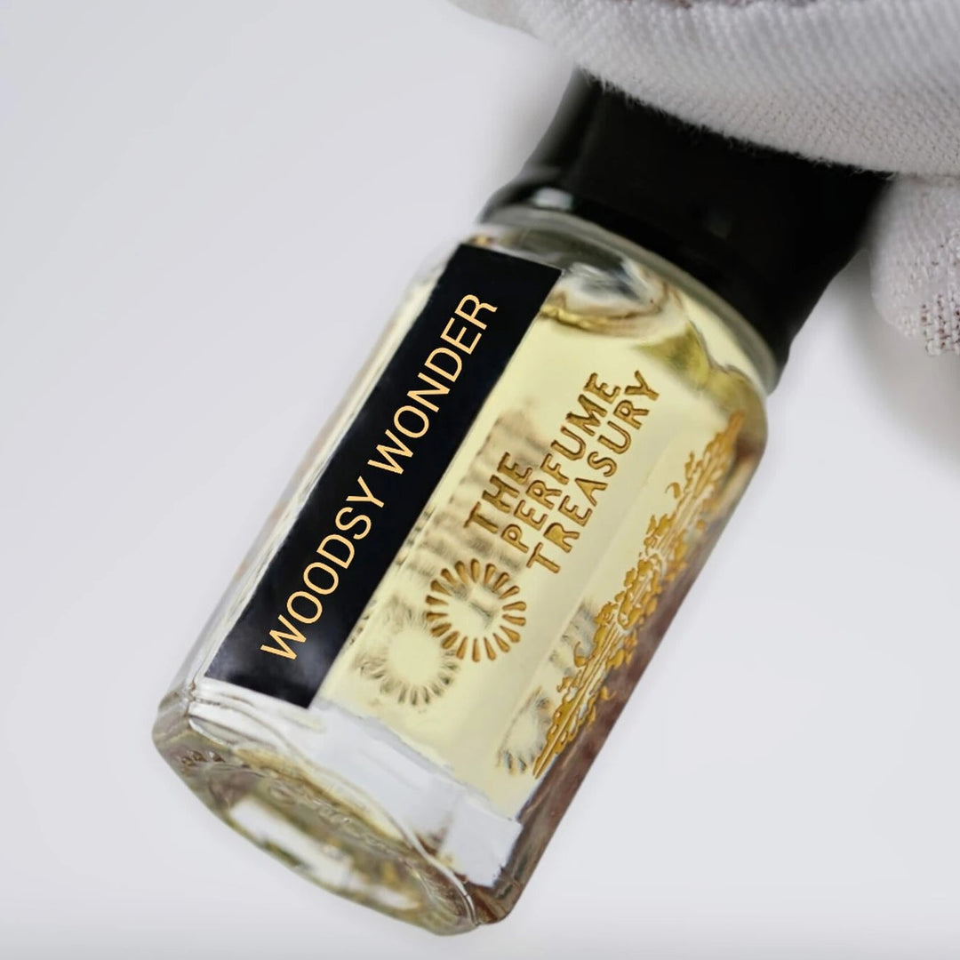 Close-up of Woodsy Wonder perfume oil by The Perfume Treasury showing the branded glass bottle and perfume oil